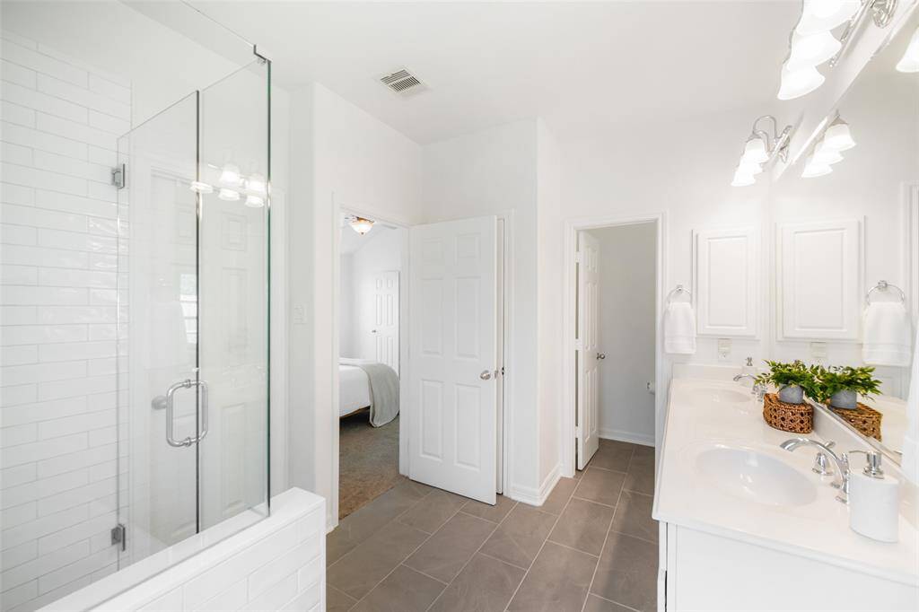 Double sinks and a long vanity over plentiful cabinet space make this bathroom easy to share. Not pictured is the large walk-in closet.