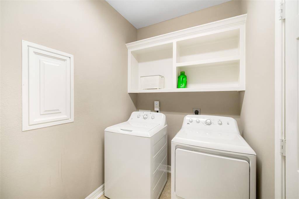 The laundry room includes open shelving for storage, as well as a handy manifold panel at left for ease in water cut off to the home if needed.
