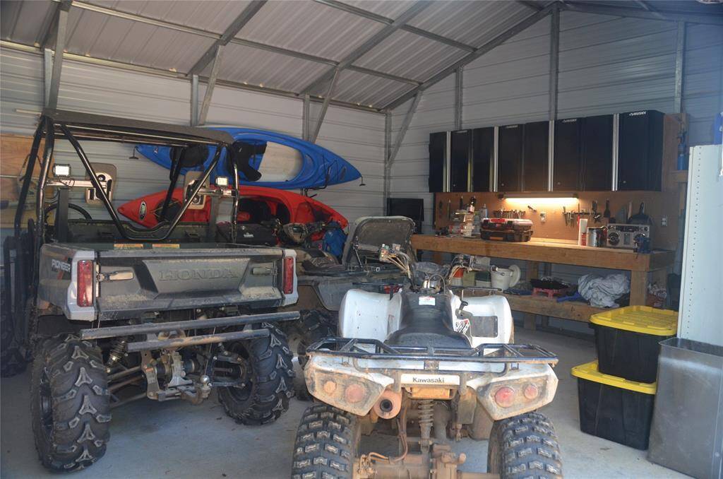 Garage features a Work area. 4 Wheeler, Side by Side and Kayaks Included!