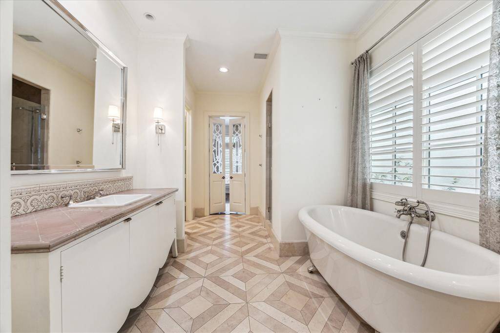 Here's a view showcasing one of the elegant sinks, the luxurious stand-alone tub, and the spacious walk-in shower.