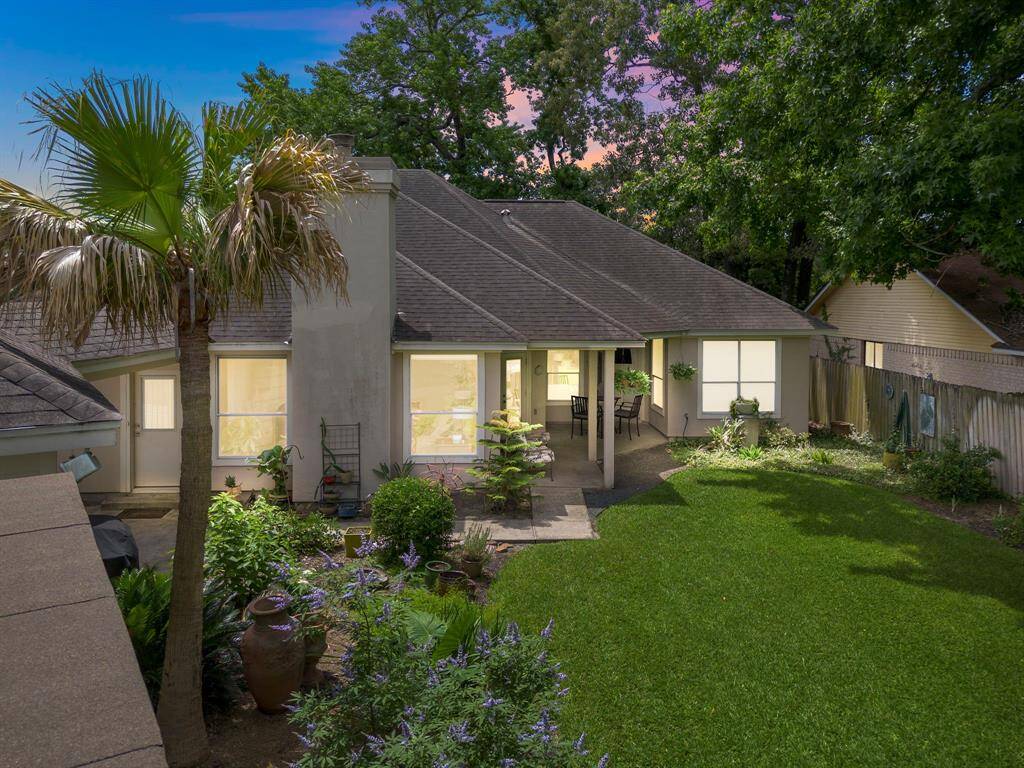 Charming home with a welcoming path leading to a grand entrance. Surrounded by lush greenery, it offers privacy and curb appeal.