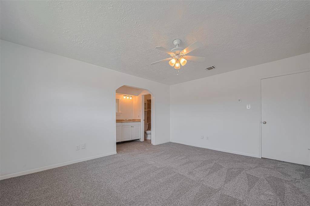 View of large primary bedroom with brand new carpet.