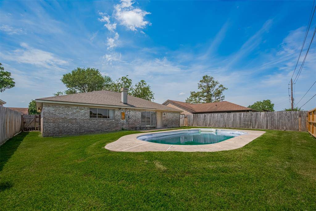 Large backyard area with in-ground vinyl pool.
