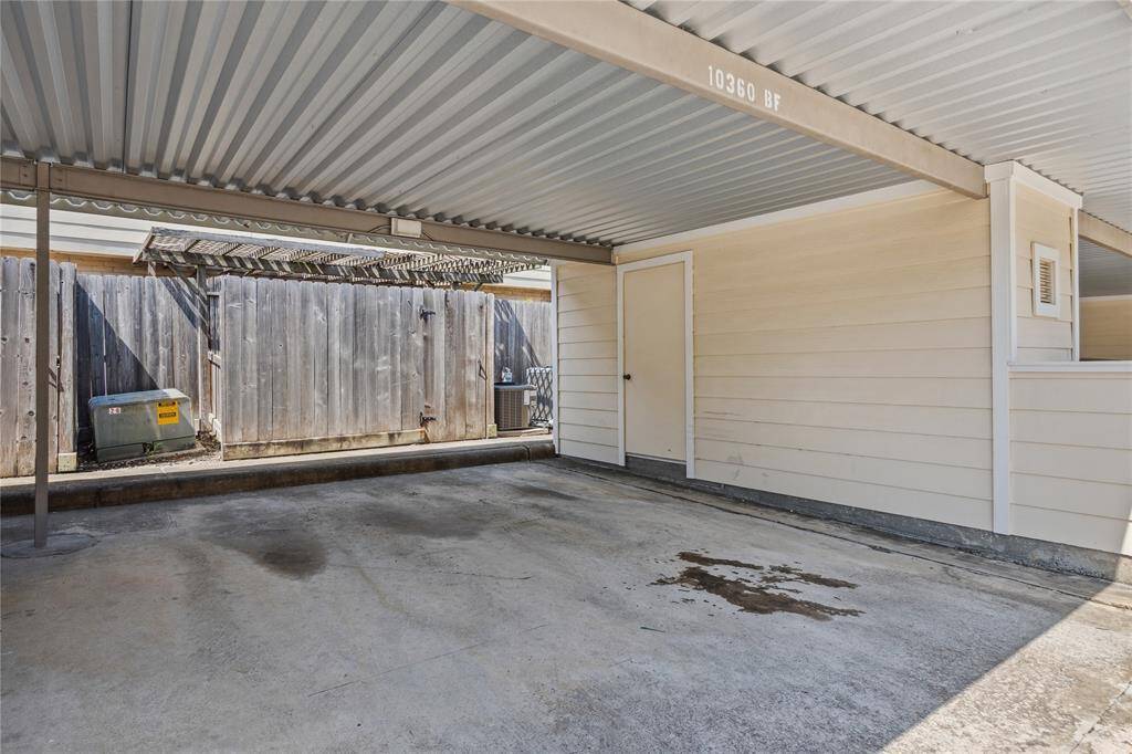 Covered two-car carport located just behind the unit, complete with a secure storage space for added convenience