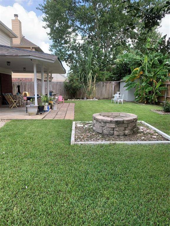 The Oasis backyard comes equipped with a built in firepit, covered porch and trees for shade.