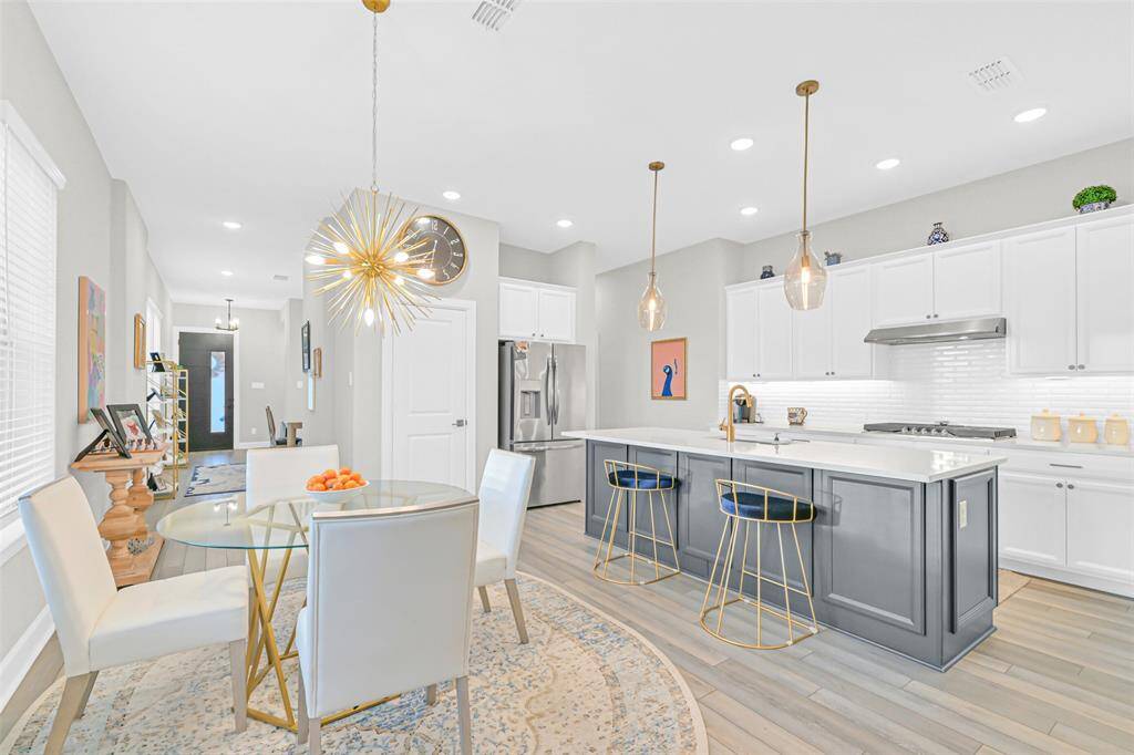 The modern kitchen effortlessly into a light-filled breakfast area, where bold lighting and stylish finishes create an elegant everyday setting.