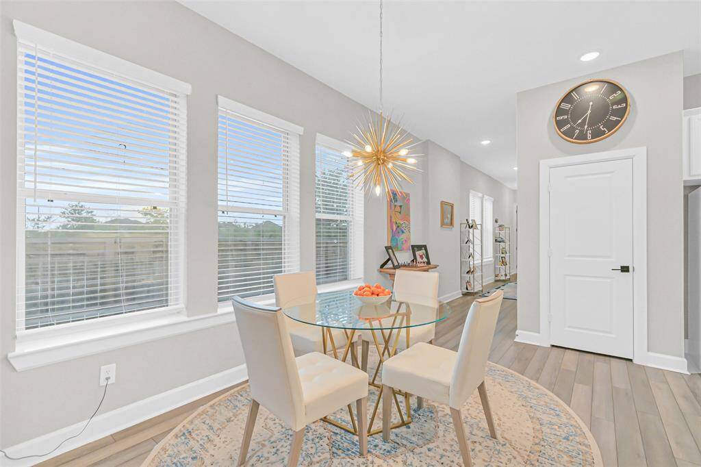 Surrounded by windows, this cozy breakfast nook boasts a dramatic gold sputnik chandelier as the focal point, while the oversized windows lend views to the spacious backyard.