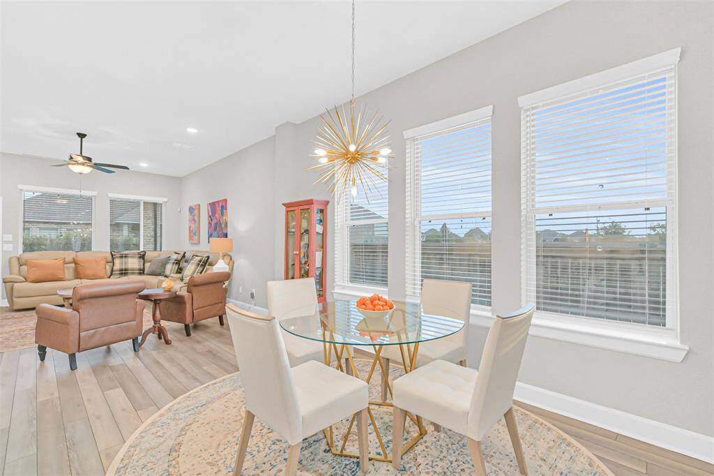 This cheerful breakfast space is designed for gatherings, nestled between the kitchen, dining, and living area for seamless entertaining in a sunlit corner of the home.