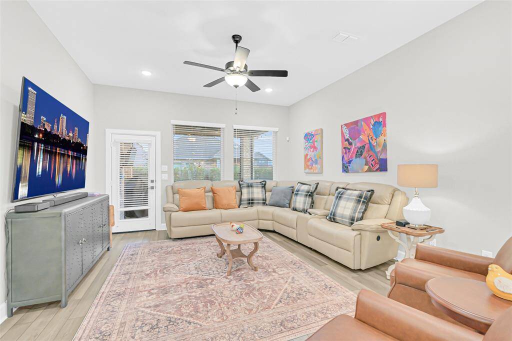 The spacious living area is perfect for entertaining, featuring recessed lighting, abundant space for flexible furniture arrangement, and a harmonious mix of textures and colors.