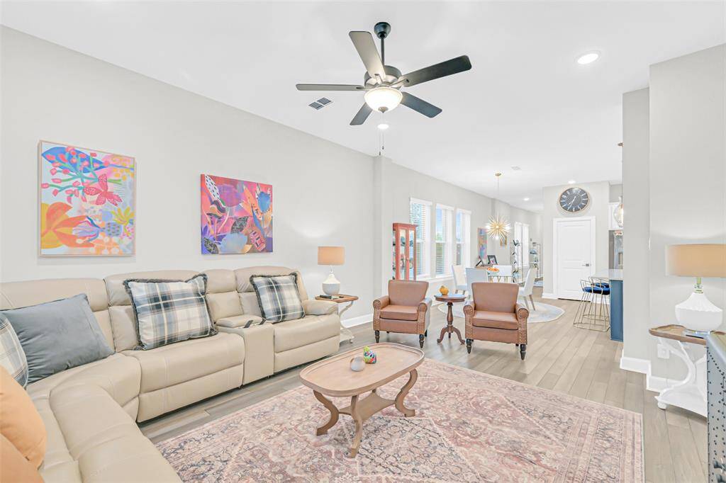 An open-concept layout connects the living and dining spaces, blending comfort and elegance with neutral tones, luxury LVP flooring, and smooth walls for vibrant artwork.