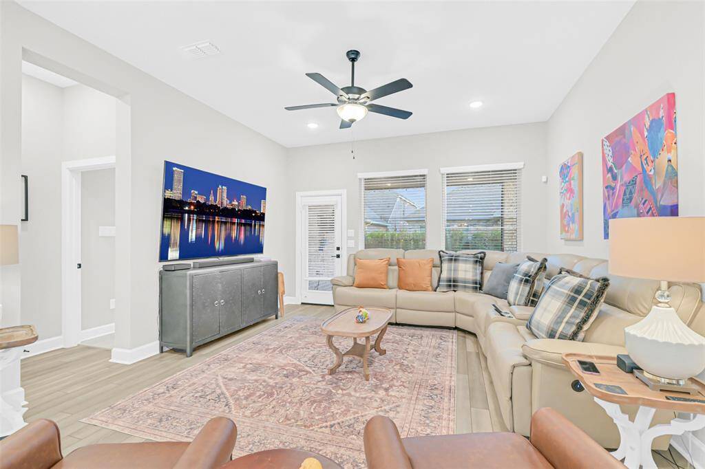 Unwind in this welcoming living room, featuring serene backyard views and easy access to the outdoor patio—perfect for relaxing or entertaining.