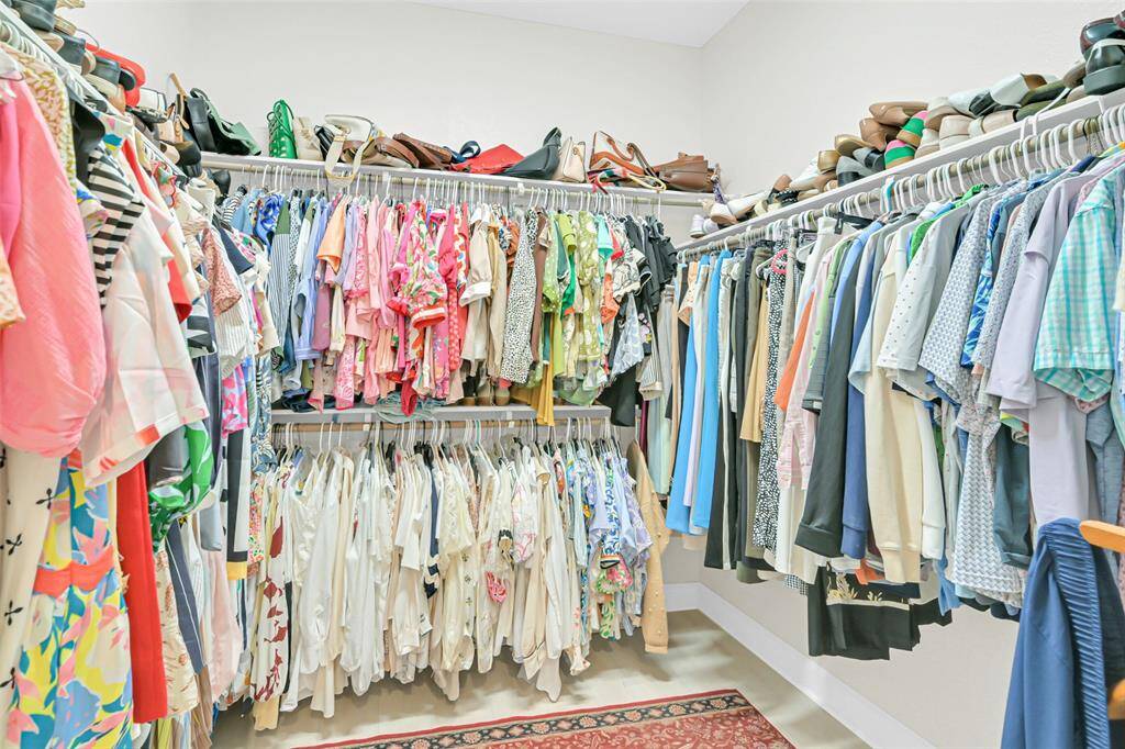 A true walk-in closet offering abundant hanging space, dual-tiered shelving, and dedicated storage—perfect for organizing any wardrobe with ease.