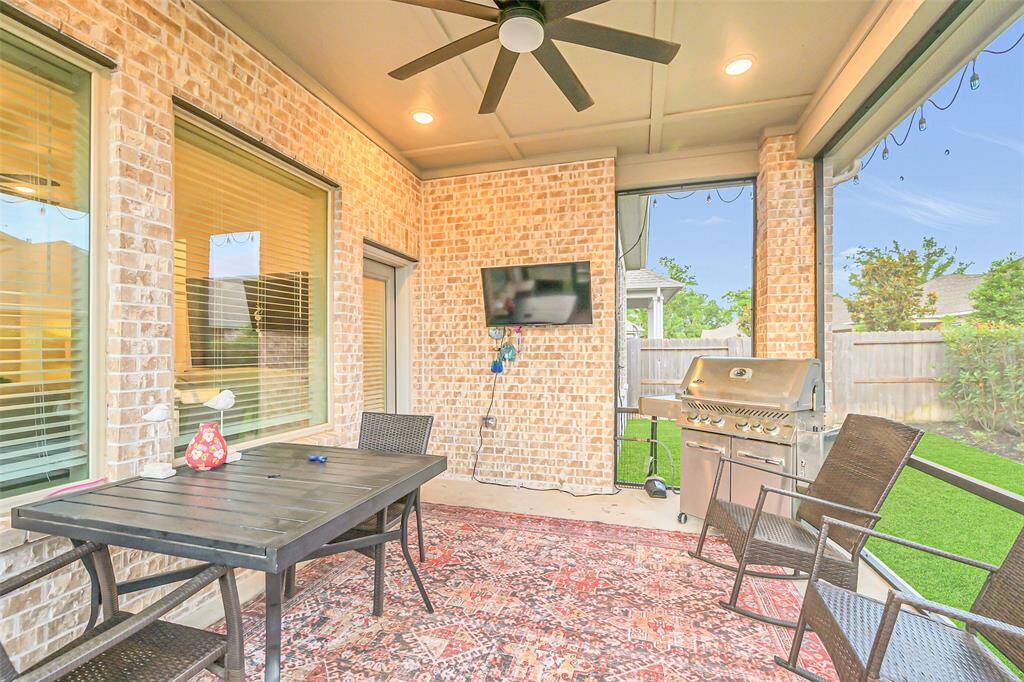 This enclosed patio is built for comfort, complete with a ceiling fan, custom protective screens, recessed lighting, and plenty of space for outdoor dining or lounging.