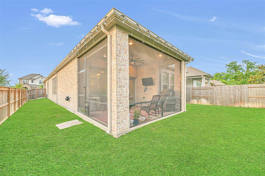Enjoy privacy and tranquility in the spacious backyard, highlighted by a fully screened-in patio—ideal for relaxing outdoors without the bugs. Framed by classic brick and manicured grass, this inviting space is perfect for both quiet moments and entertaining guests.