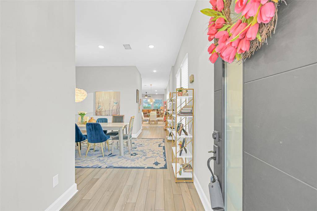 The entry foyer opens to a bright and airy floor plan, providing sightlines and a harmonious transition through the home’s designated spaces.