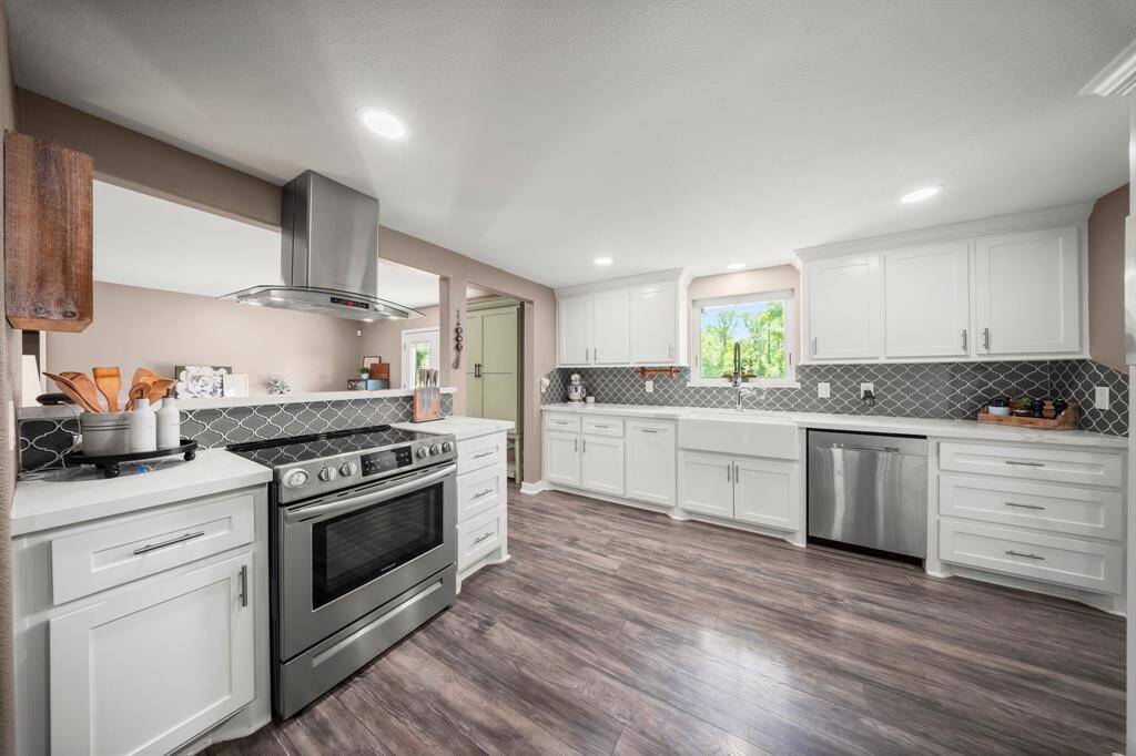 Charming backsplash tile design and a beautiful window overlooks the serene outdoors.
