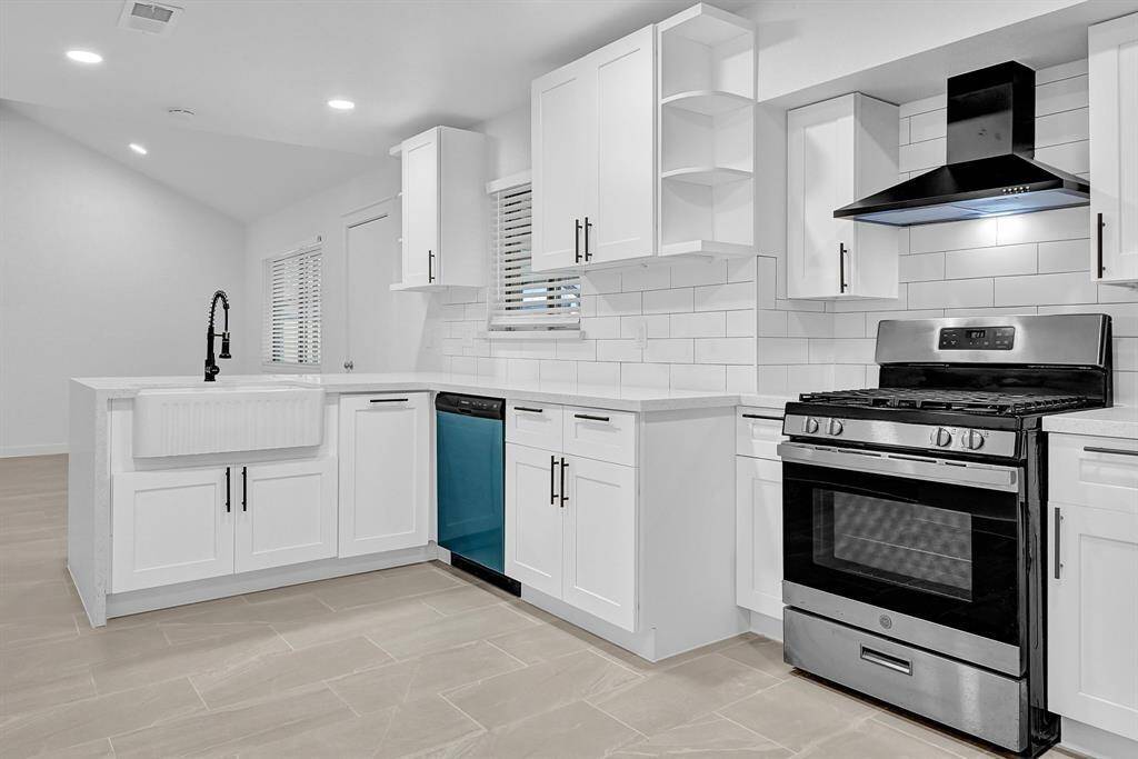 This room features a modern, minimalist design with neutral tile flooring, white walls, and a ceiling fan. Natural light comes through the window with blinds, and there's a door leading to an adjoining space.