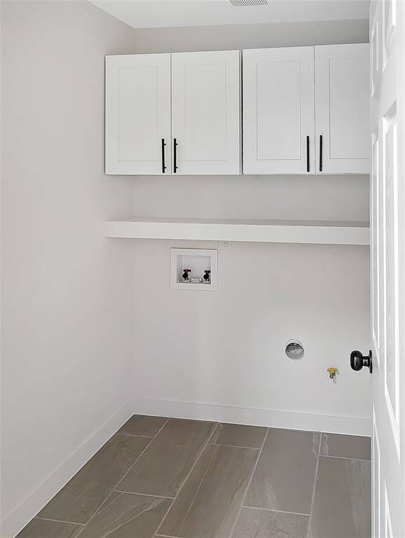 This room features neutral walls, recessed lighting, and large gray floor tiles, creating a modern and clean look.