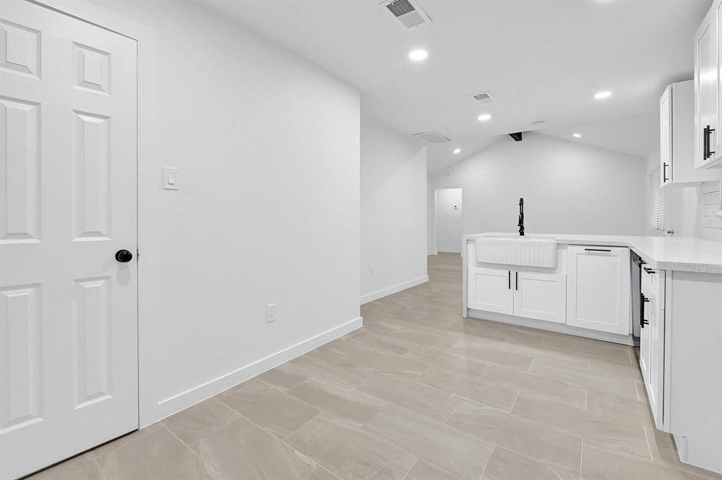 This photo showcases the backyard of a home featuring a spacious, well-maintained lawn, a covered patio area, and a wooden fence providing privacy. Ideal for outdoor activities and relaxation.