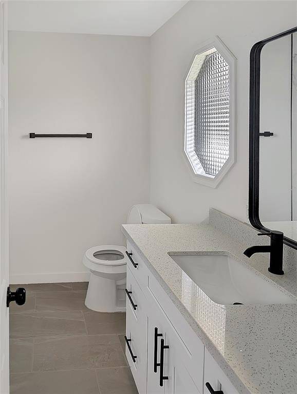 Modern kitchen with sleek white cabinetry, stainless steel appliances, and a stylish farmhouse sink. The space features a subway tile backsplash and elegant fixtures, offering a clean and contemporary look.