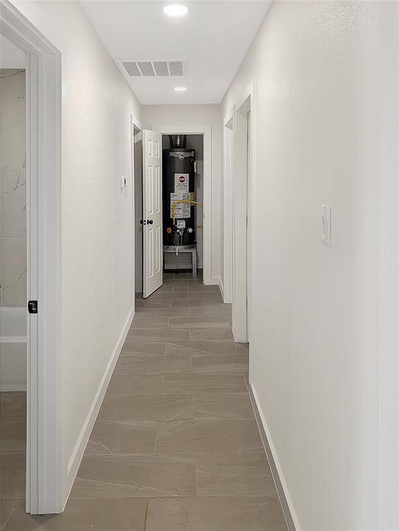 This modern kitchen features white cabinetry, a sleek subway tile backsplash, and a spacious countertop. It includes a black refrigerator and oven, with recessed lighting enhancing the clean, bright ambiance. Perfect for a contemporary homebuyer.