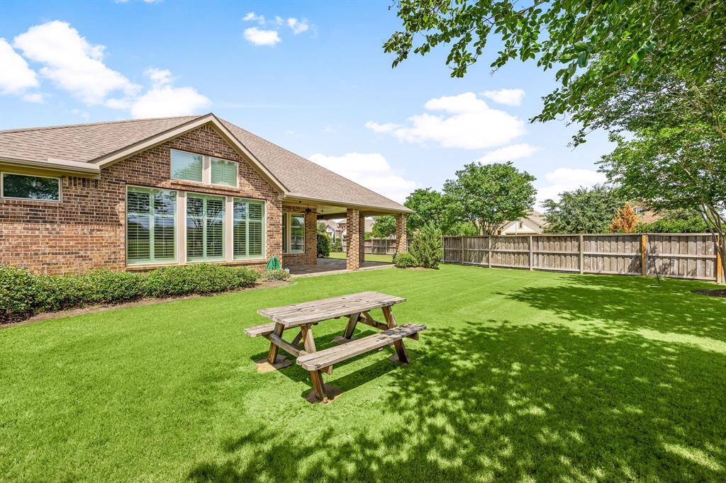 Step out onto the expansive L-shaped covered patio perfectly designed to accommodate both a dining area and additional seating for relaxing or entertaining. Enjoy peaceful water views, lush green space, and direct access to the walking trail just beyond the backyard, blending outdoor living with serene natural surroundings.