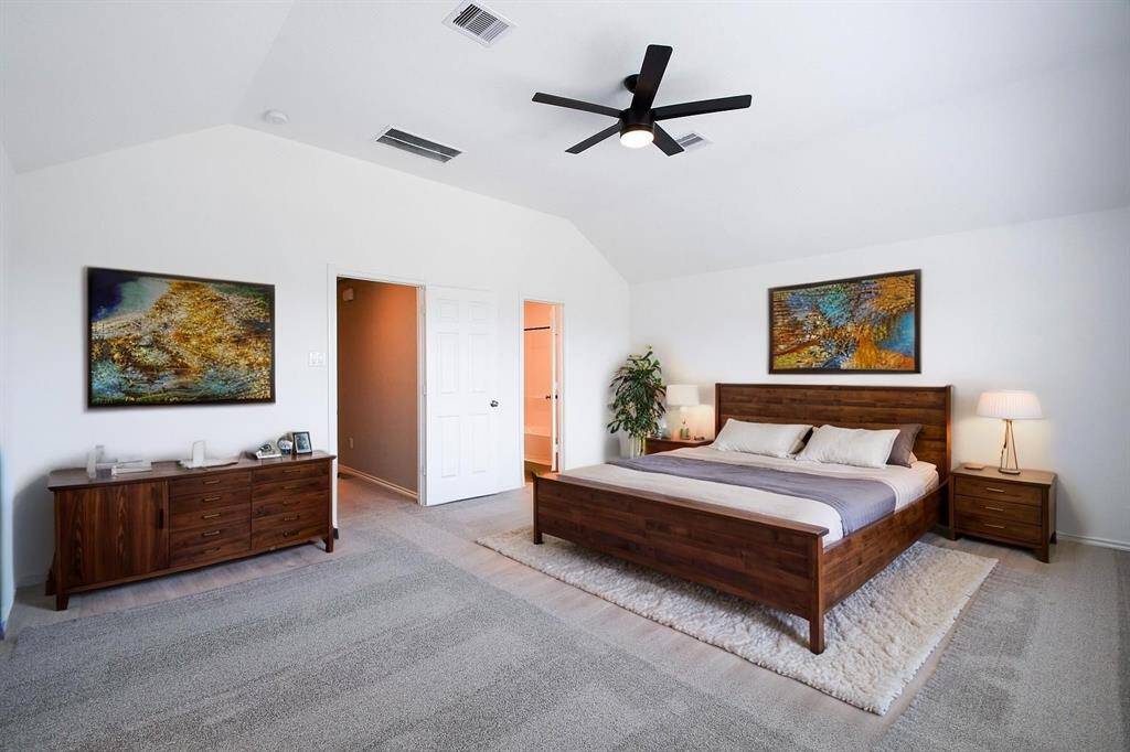 The main bedroom boasts a high ceiling and the luxury of separate his-and-hers walk-in closets. Its generous proportions easily accommodate a king-size bed, two nightstands, and additional furnishings.