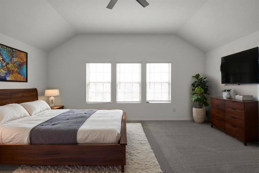 Sunlight streams through three expansive windows, illuminating another perspective of the main bedroom's tranquil and secluded comfort.
