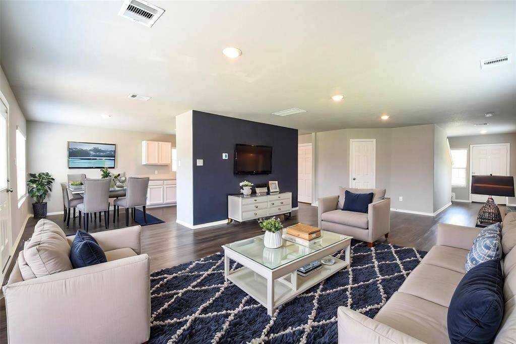 See the potential! This spacious living area can easily accommodate a large dining table, as demonstrated in this thoughtfully staged image.