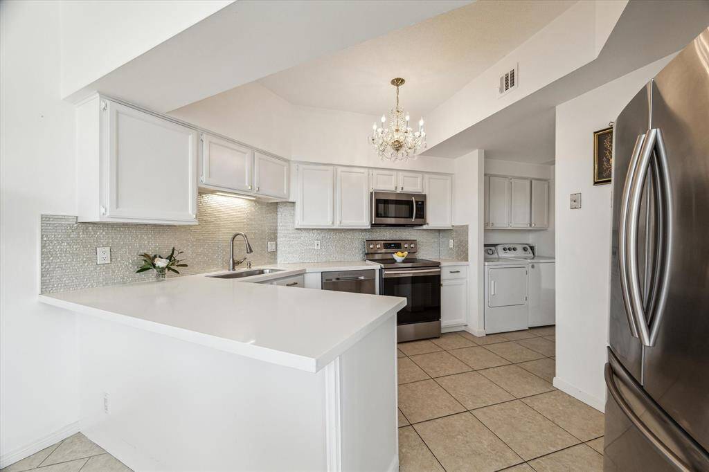 Kitchen - Quartz countertop and glass tile backsplash.