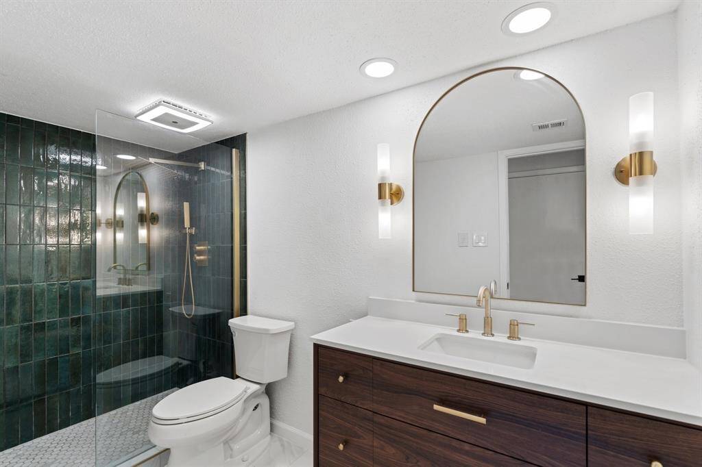 The primary bedroom is spacious, boasting a modern ceiling fan and ample natural light from large windows, creating a serene and inviting atmosphere. The bedroom boasts two spacious closets, one of which is a walk-in!