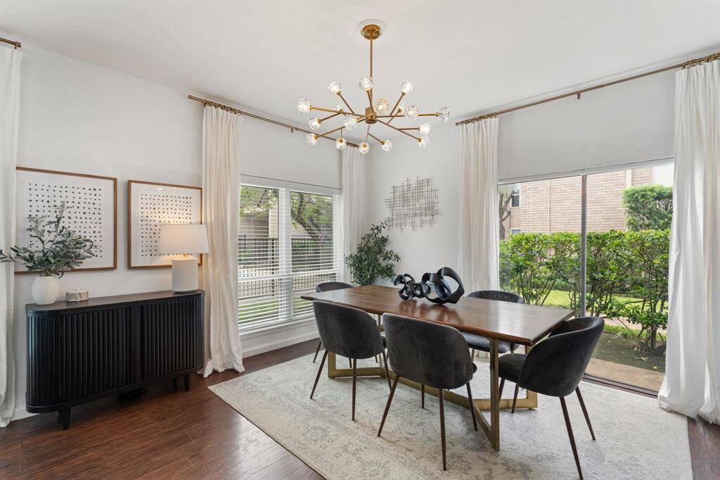 This spacious living room features high ceilings, a cozy fireplace, and abundant natural light from large windows, creating a welcoming and stylish ambiance.