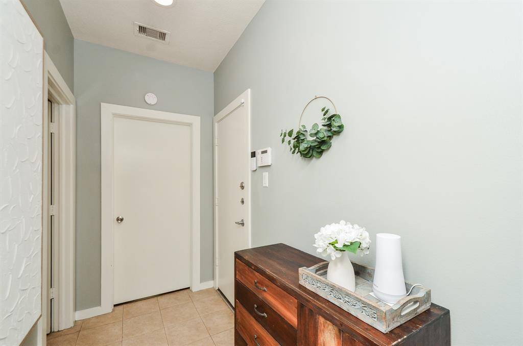 A welcoming entryway with a black front door, a window for natural light, and a staircase leading up.
