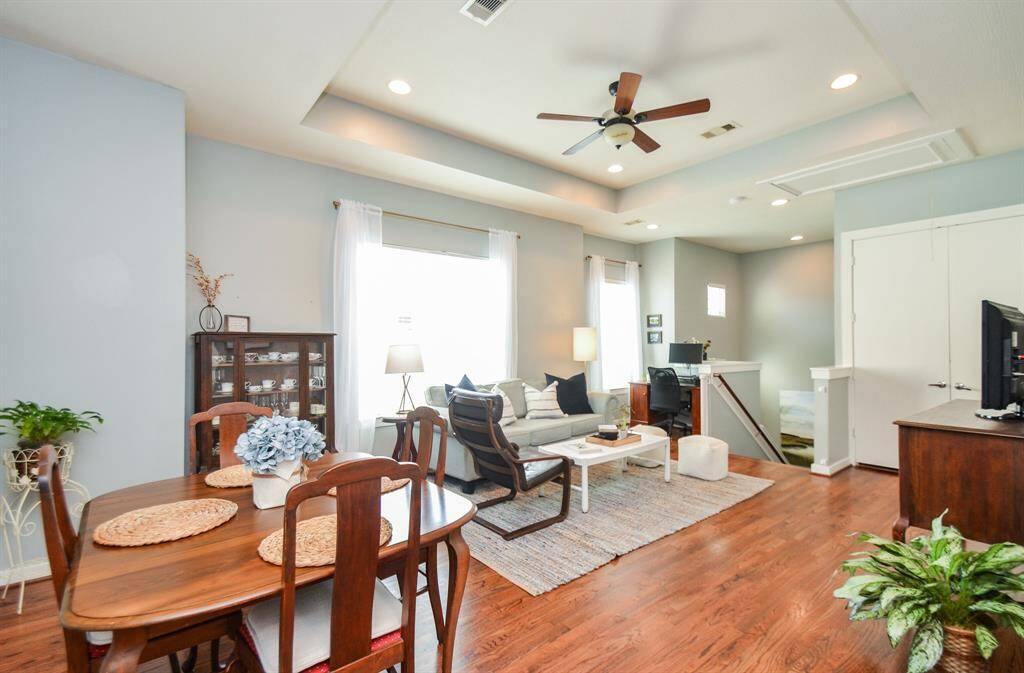 Charming dining area with hardwood floors, featuring a wooden table set for four. Bright and inviting space for family meals.