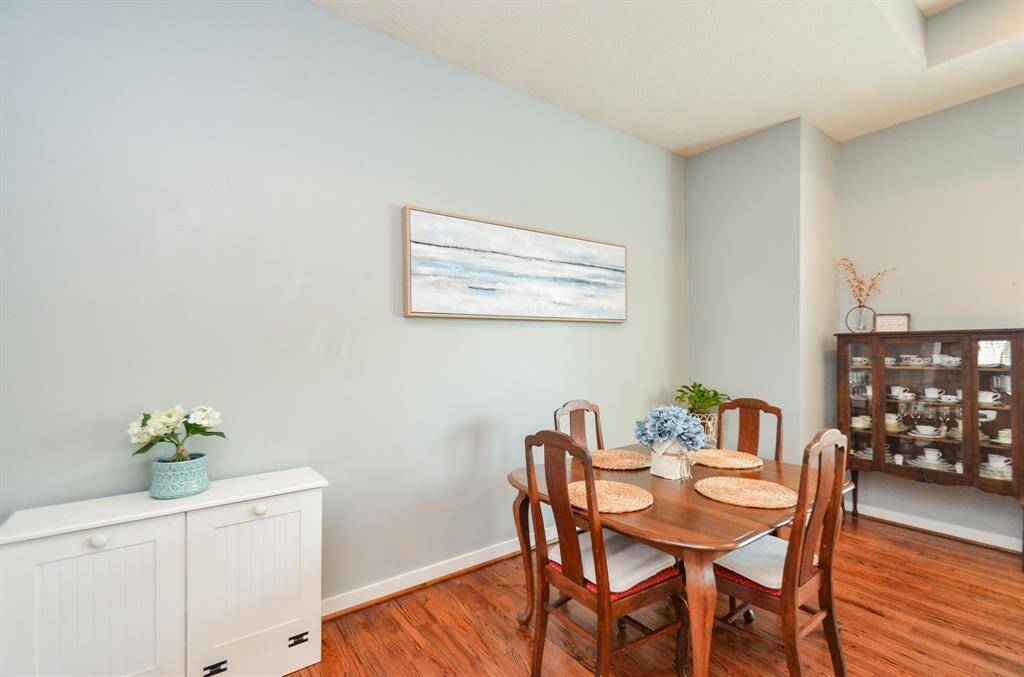 Large Dining area with a wooden table plus a glass cabinet displays fine china and complementing the hardwood floor.