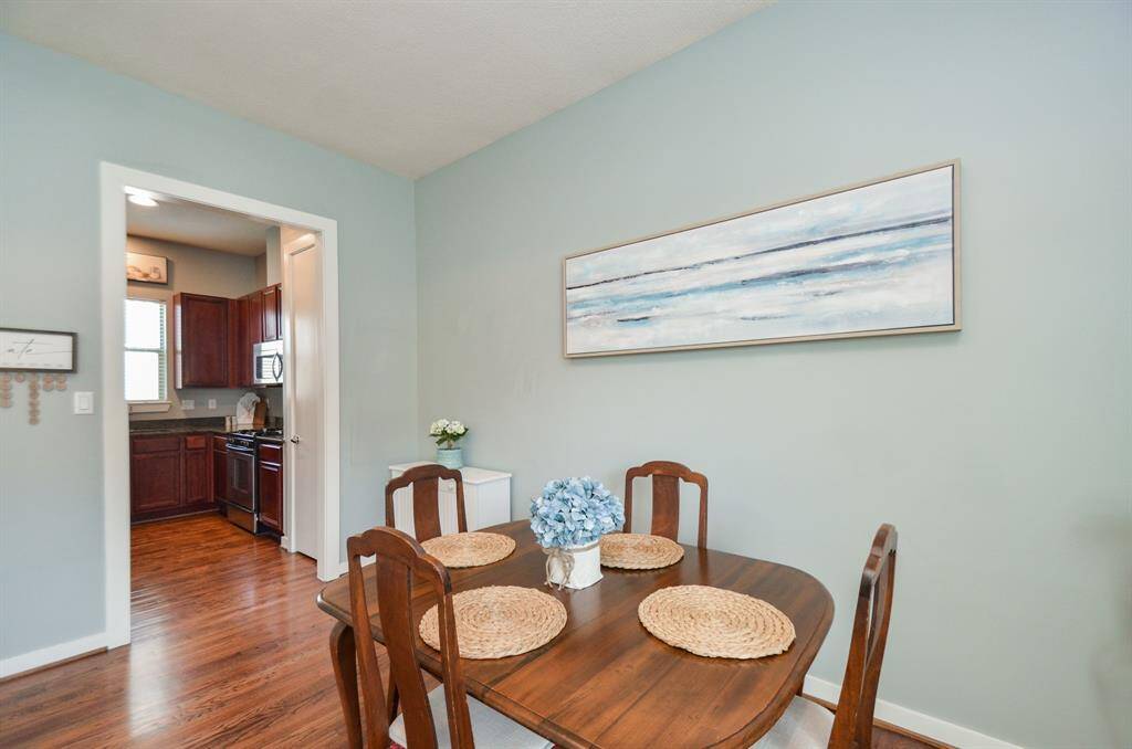 Kitchen features elegant dark wood cabinets, granite countertops, and stainless steel appliances, offering a warm and sophisticated space for cooking and entertaining.