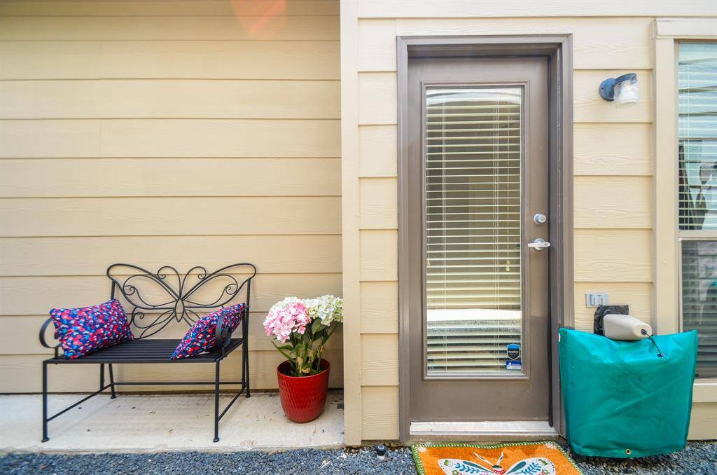 This photo showcases a bright and welcoming entryway with light green walls and tile flooring. It features a wooden console table adorned with a decorative tray, vase, and flowers, adding a touch of elegance. A simple wreath hangs on the wall, complementing the clean, minimalist design.