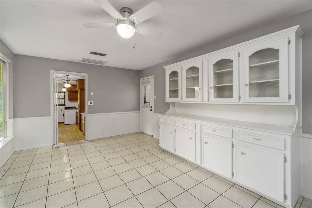 The spacious breakfast room has lovely built in China cabinets. This room leads to the laundry room and garage. Note the side door that leads to the driveway.