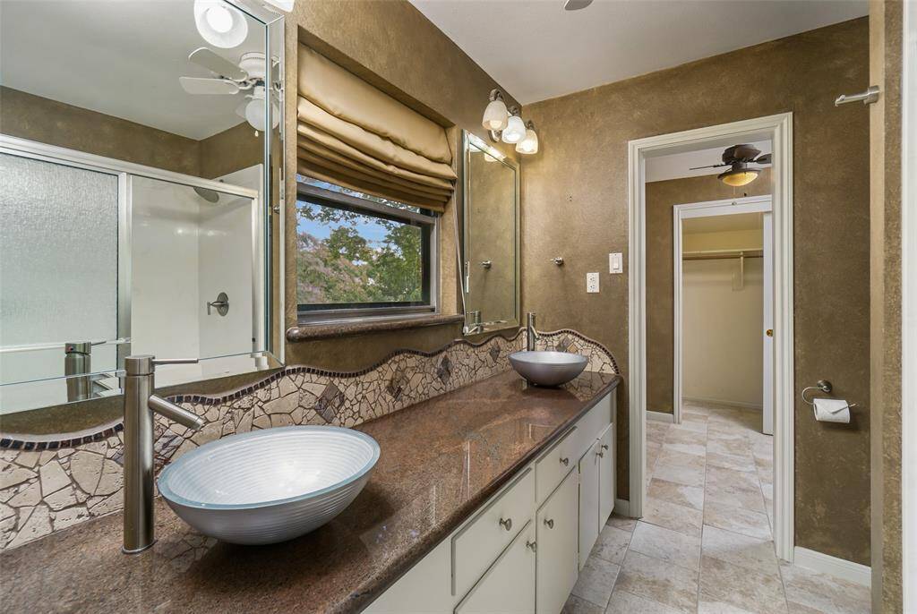 Jack & Jill bathroom features granite counters, two sinks, large standing shower with bench and a "dressing area" & closet to each side.