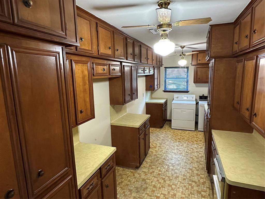 The spacious laundry room has what the seller calls "a ridiculous amount" of storage in cabinets. Plenty of room for "work" to be done. There's space for a fridge and a deep freezer in addition to the washer and dryer.