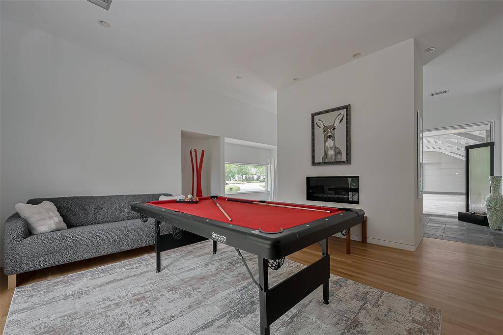 Open-concept game room with fireplace and access to the covered breezeway makes entertaining easy.