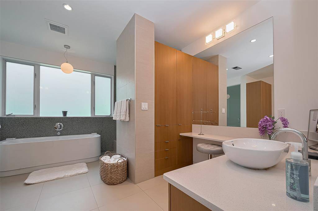 Spa-inspired full bath features a frameless glass shower, modern tile, and stylish vanity.