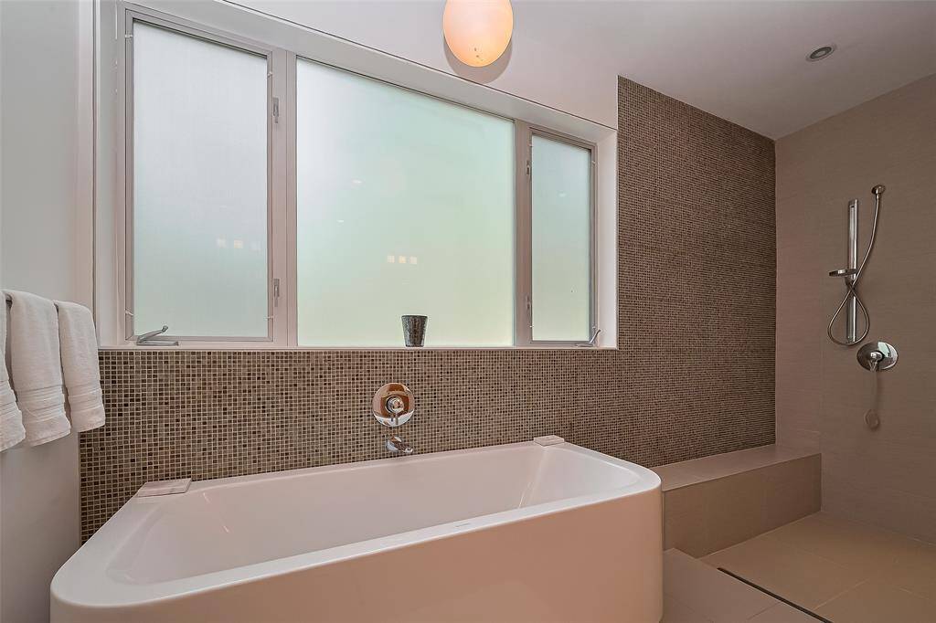 Seamless shower design with bench and elegant tilework.