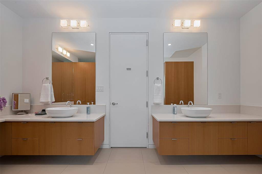 His-and-hers vanities with large mirrors and contemporary lighting.