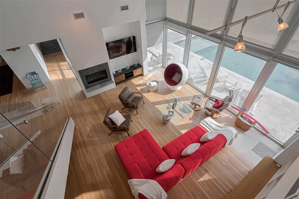 Stunning view of living space and pool through soaring windows.