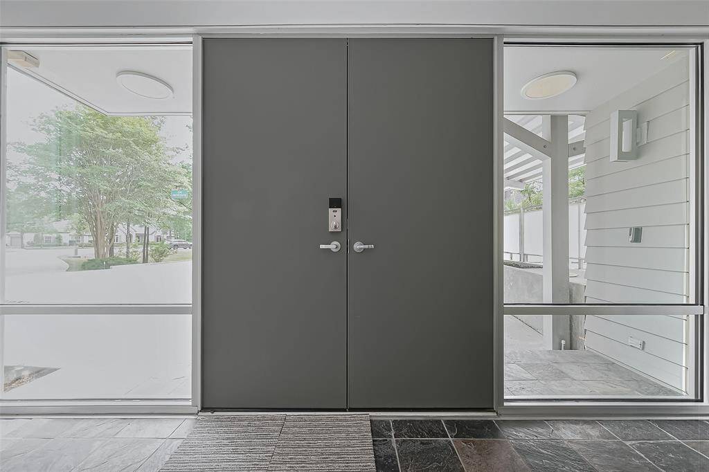 Grand double-door entrance with floor-to-ceiling sidelights welcomes you into this striking contemporary home.