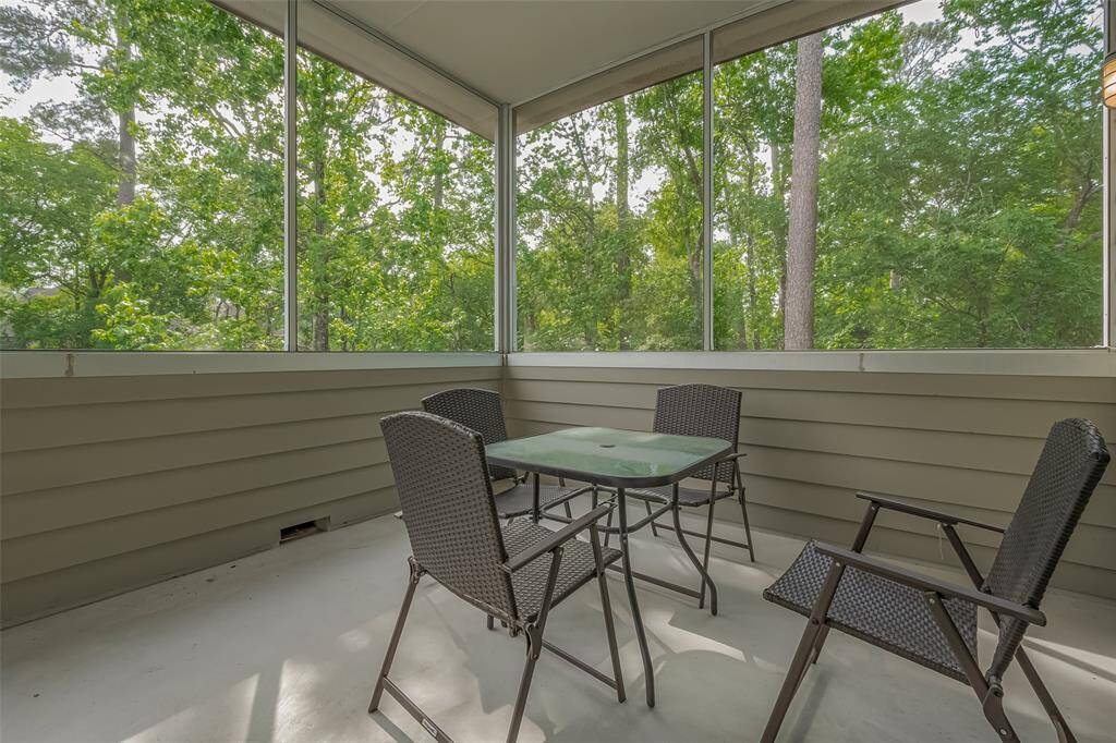 Tranquil screened-in porch offers shaded comfort with scenic forest views.