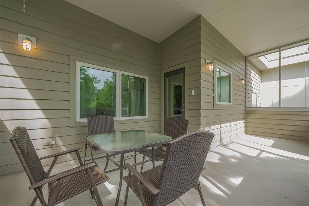 Covered patio with durable siding and ample seating space, perfect for outdoor dining or relaxing.