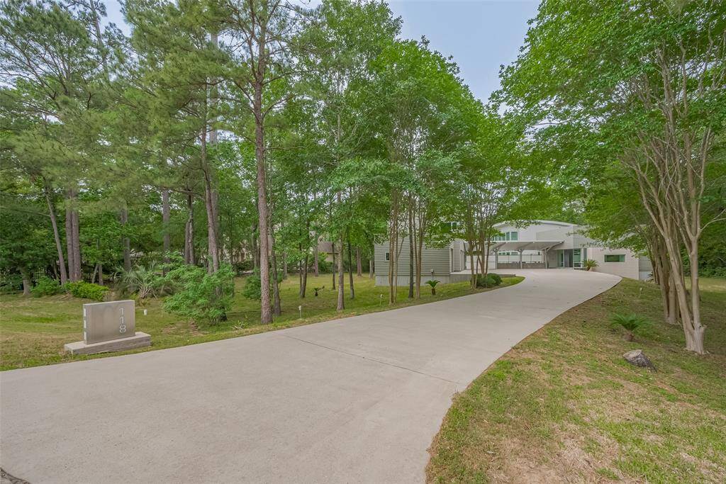 Expansive lot with lush surroundings, a large modern home, and inviting pool area.