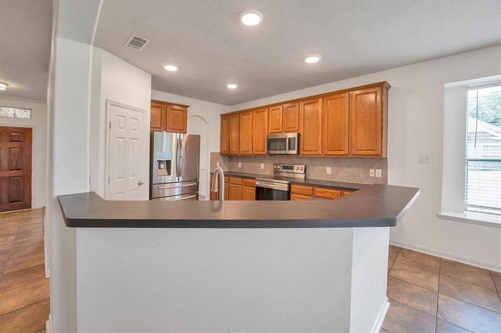 This modern kitchen features sleek stainless steel appliances, abundant cabinets, and generous counter space.